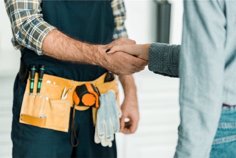 Plumber and customer shaking hands